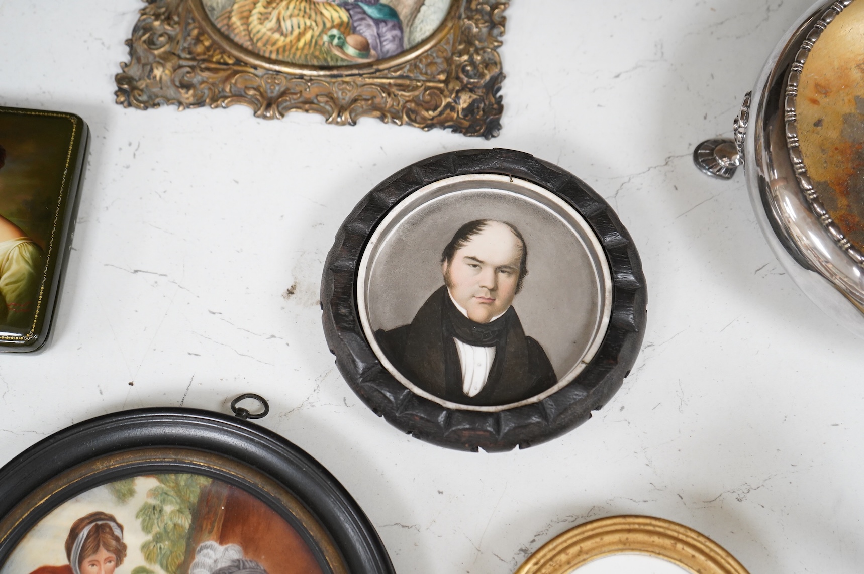 A collection of 19th century porcelain panels, pot lids and plaques to include a pair of hand painted floral lids, Russian lacquered box depicting a lady and a late 19th century Continental brass framed convex oval ename